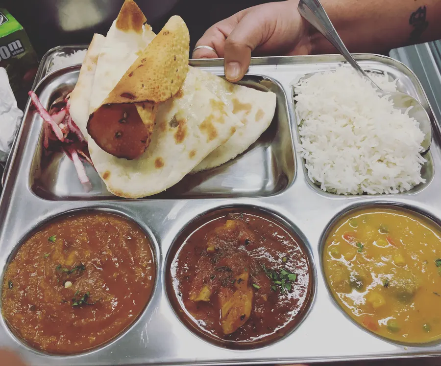 A thali tray of Shahi Aroma curries, rice and bread